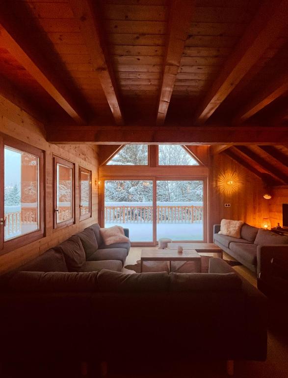 - un salon avec des canapés et une grande fenêtre dans l'établissement Chalet 14 personnes Alpe d Huez, à Oz