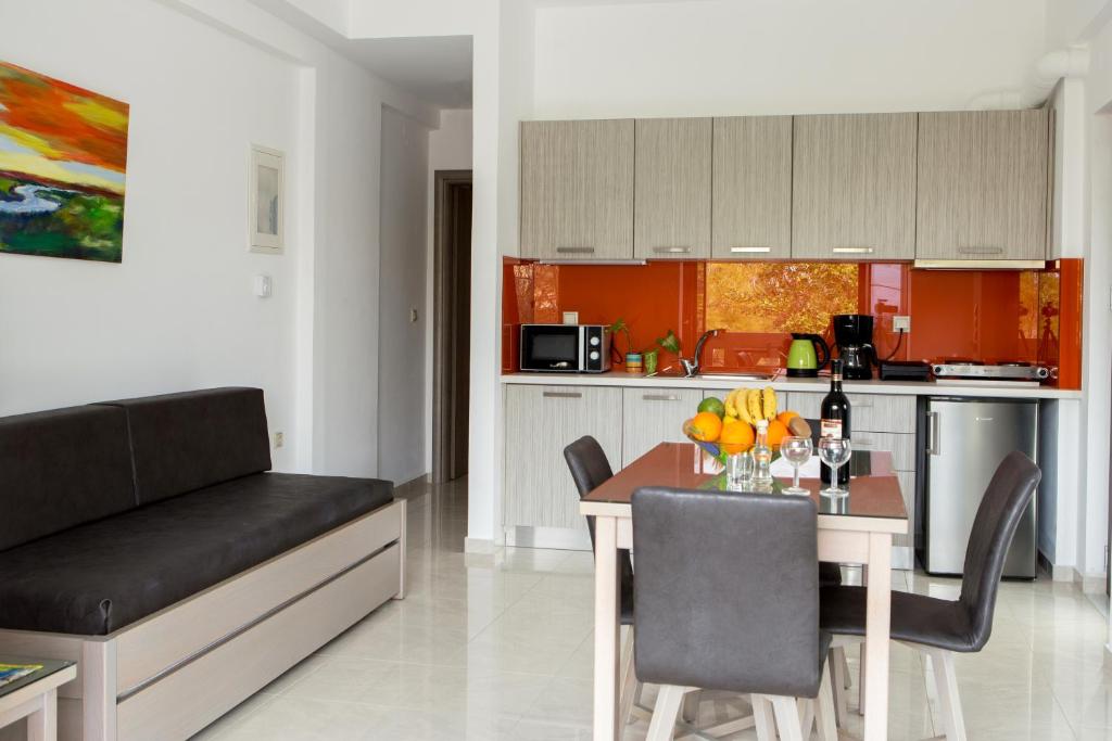 a kitchen and dining room with a table and a couch at Angela Apartments in Kato Daratso