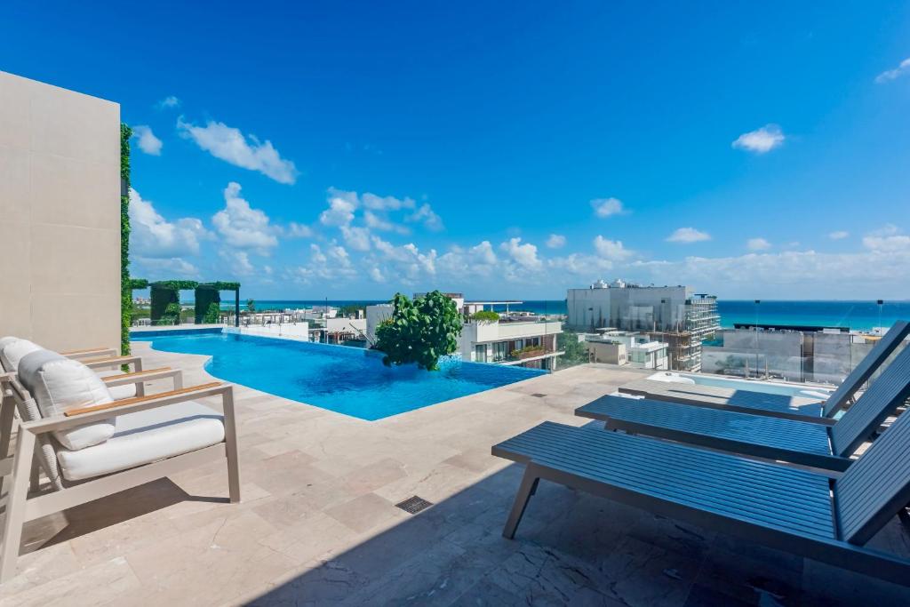 プラヤ・デル・カルメンにあるPlaya Azul Studio - Coco Beach Iのスイミングプールと海の景色を望むパティオ