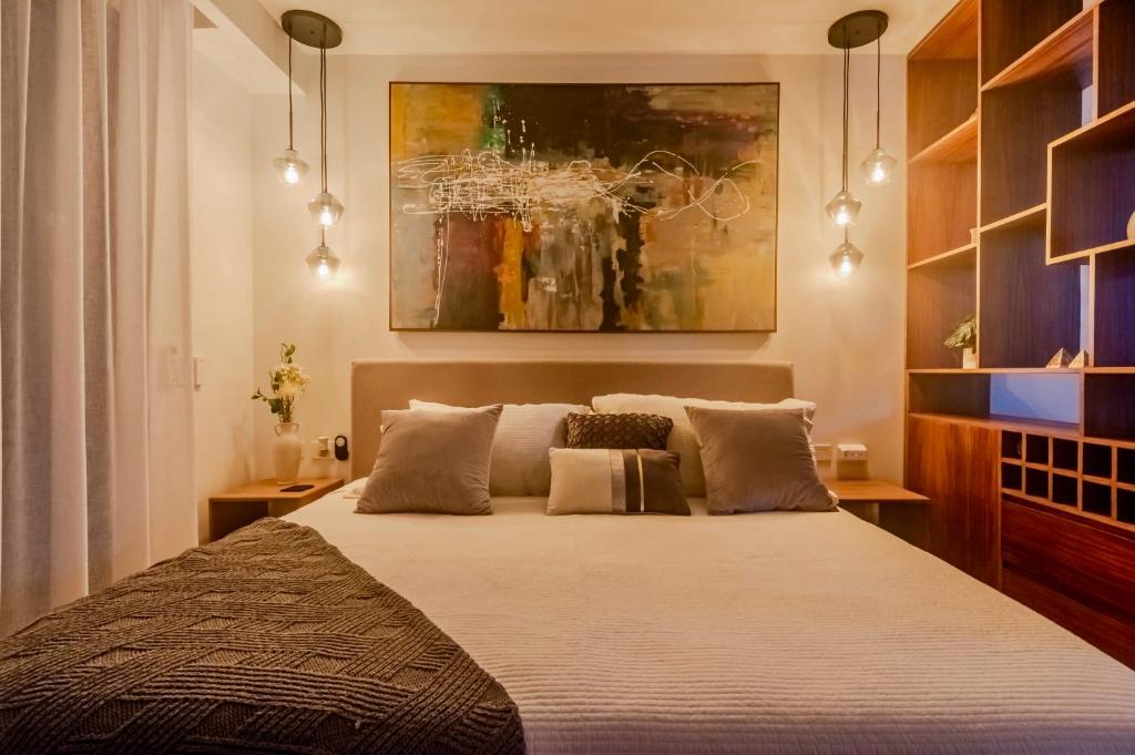a bedroom with a bed and a painting on the wall at Playa Azul Studio - Coco Beach I in Playa del Carmen