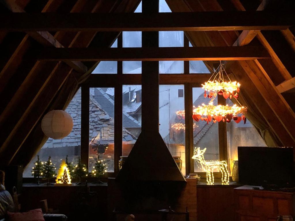 un lampadario a braccio in una stanza con luci di Natale alla finestra di Chalet Aranés Santa María cerca de Baqueira-Beret by Eth Flòc a Tredós