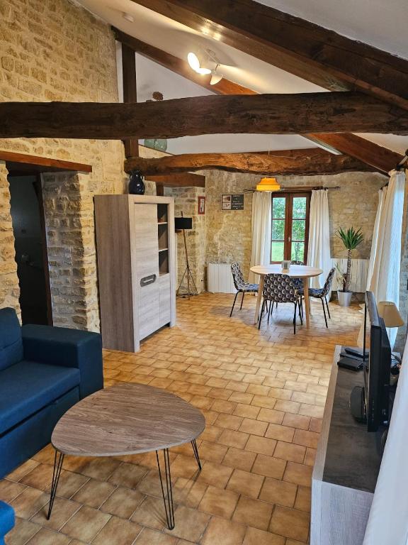 un salon avec un canapé bleu et une table dans l'établissement Le Longbeach 2, à Longueville