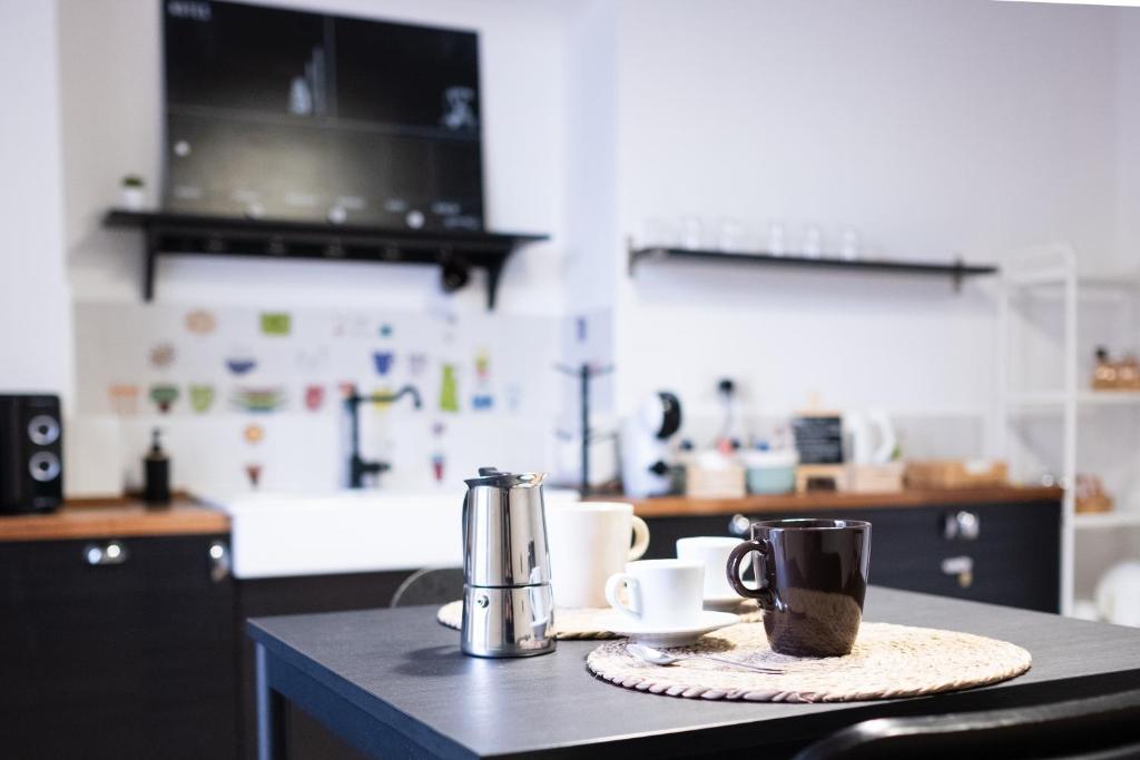 a kitchen counter with two coffee mugs on a table at I Quartieri Di Spaccanapoli B&B in Naples