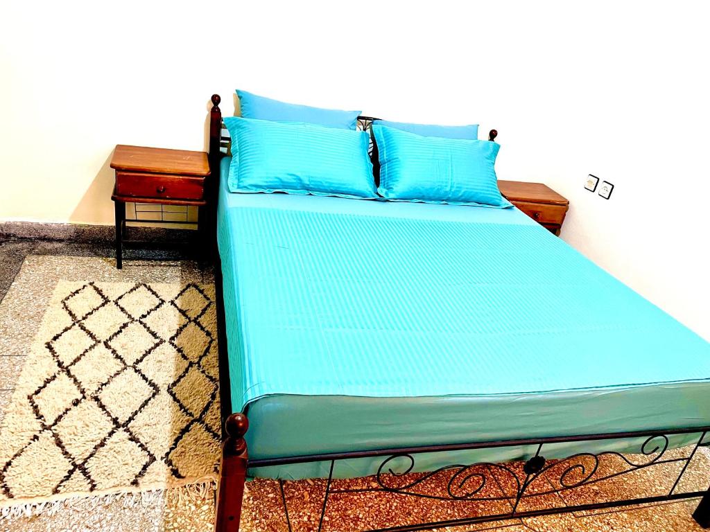 a bed with blue pillows in a room at Studio in City Center Living at Heart of It All in Er Rachidia
