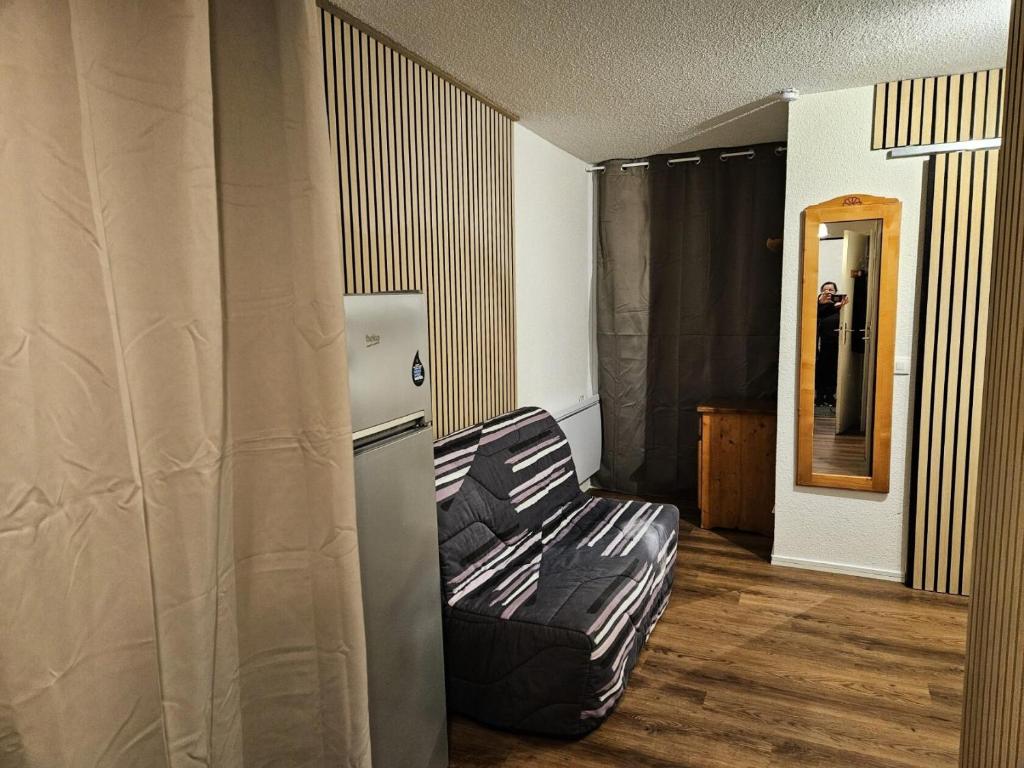 Cette chambre dispose d'un canapé et d'un réfrigérateur. dans l'établissement Résidence Les Horizons d'Huez - maeva Home - Appartement 2 pièces 4 personnes - Sélection MAE-3871, à Huez