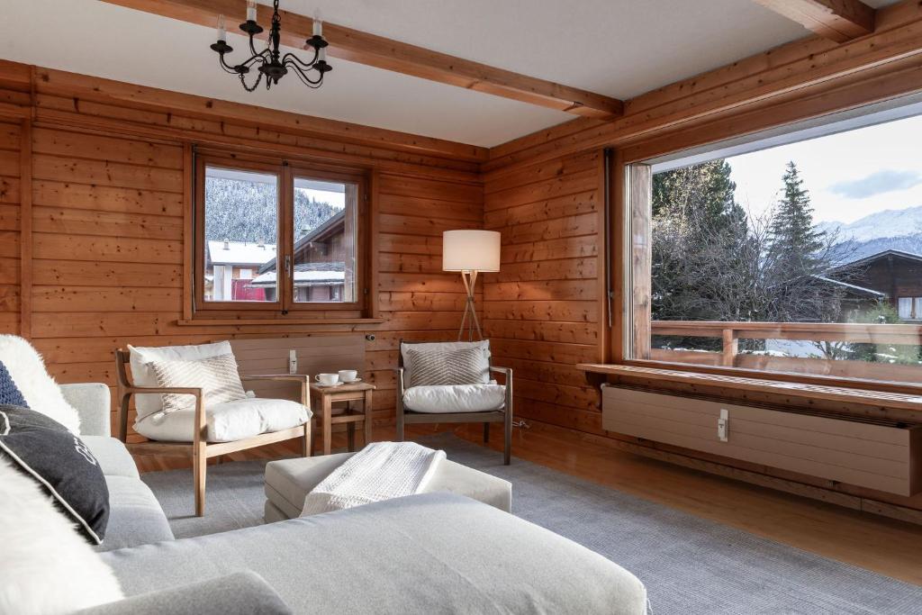 a bedroom with wooden walls and a large window at La Ruinette-cosy 2-bed, 2-bath In Verbier Centre in Verbier