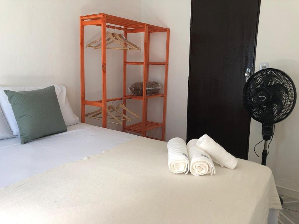 1 dormitorio con 1 cama con ventilador y toallas en Casa confortável e aconchegante, en Lençóis