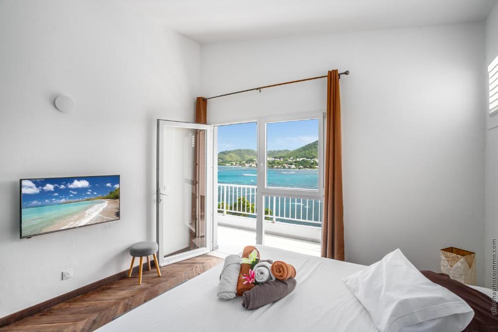 a bedroom with a bed with a view of the ocean at Sublime Villa Piscine - Trésor de la Baie in La Trinité
