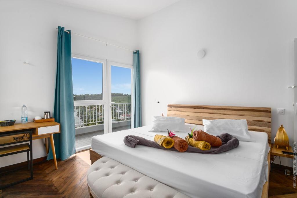 a bedroom with a large white bed with a window at Sublime Villa Piscine - Trésor de la Baie in La Trinité