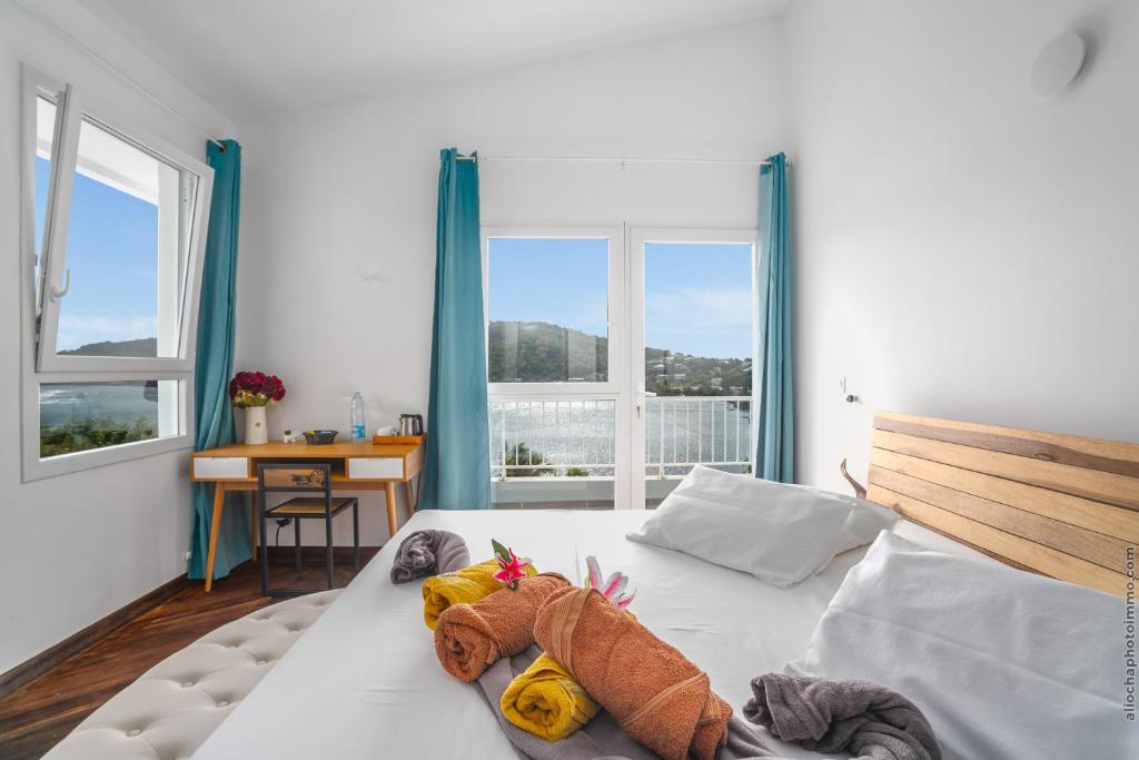 a bedroom with a bed with stuffed animals on it at Sublime Villa Piscine - Trésor de la Baie in La Trinité