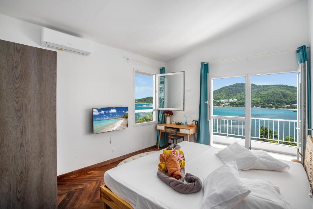 a bedroom with a bed and a large window at Sublime Villa Piscine - Trésor de la Baie in La Trinité