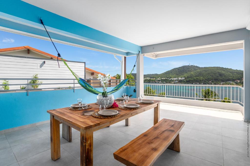 a dining room with a table and a large window at Sublime Villa Piscine - Trésor de la Baie in La Trinité