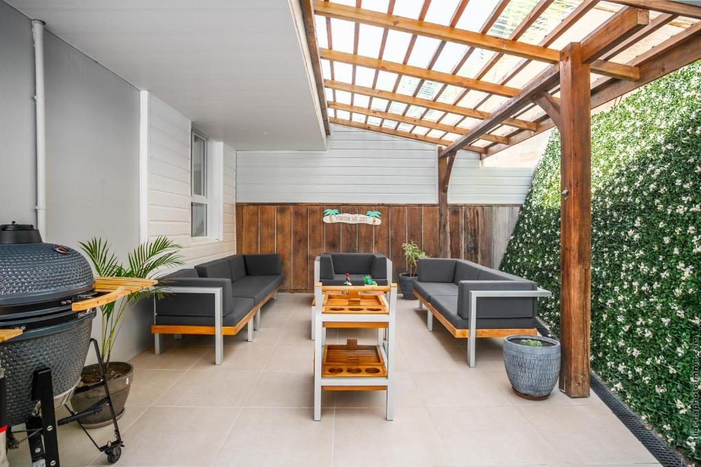 a patio with couches and a wooden pergola at Sublime Villa Piscine - Trésor de la Baie in La Trinité