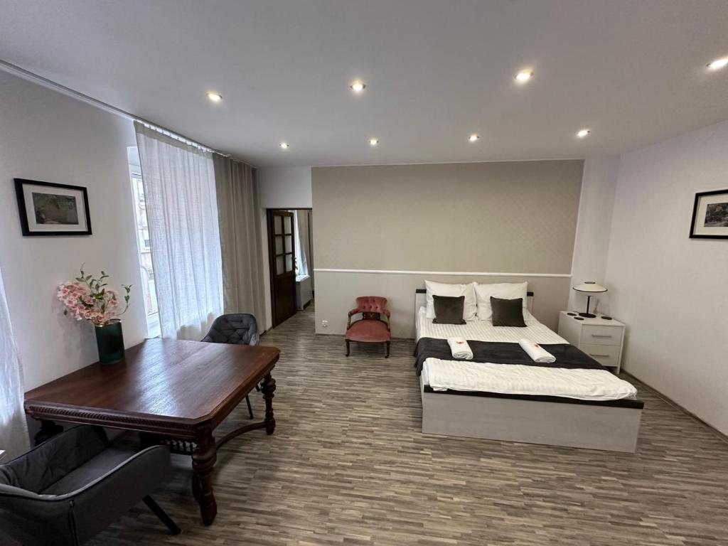 a bedroom with a bed and a desk and a table at Apartment Chorzow Center in Chorzów