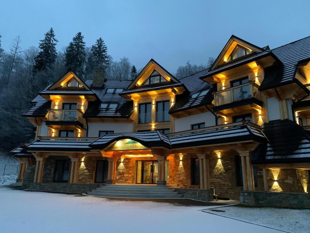 ein großes Haus mit Schnee davor in der Unterkunft GreenHill Bachleda in Zakopane