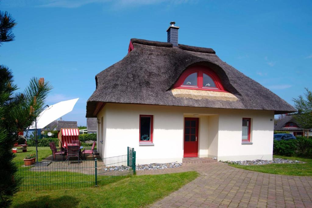een klein huis met een rieten dak bij Seemöwe in Glowe