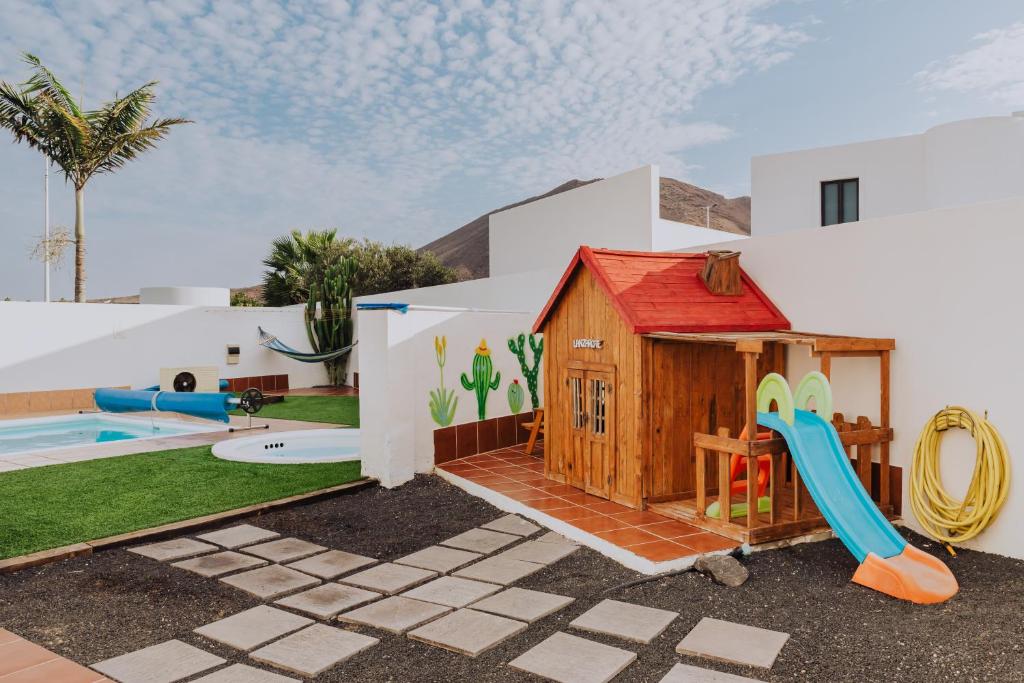a house with a playground and a slide at Villa Lanzarote Deluxe & Spa Pool in Playa Blanca