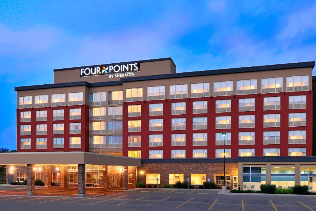 ケンブリッジにあるFour Points by Sheraton Cambridge Kitchener, Ontarioの看板が上のオフィスビル