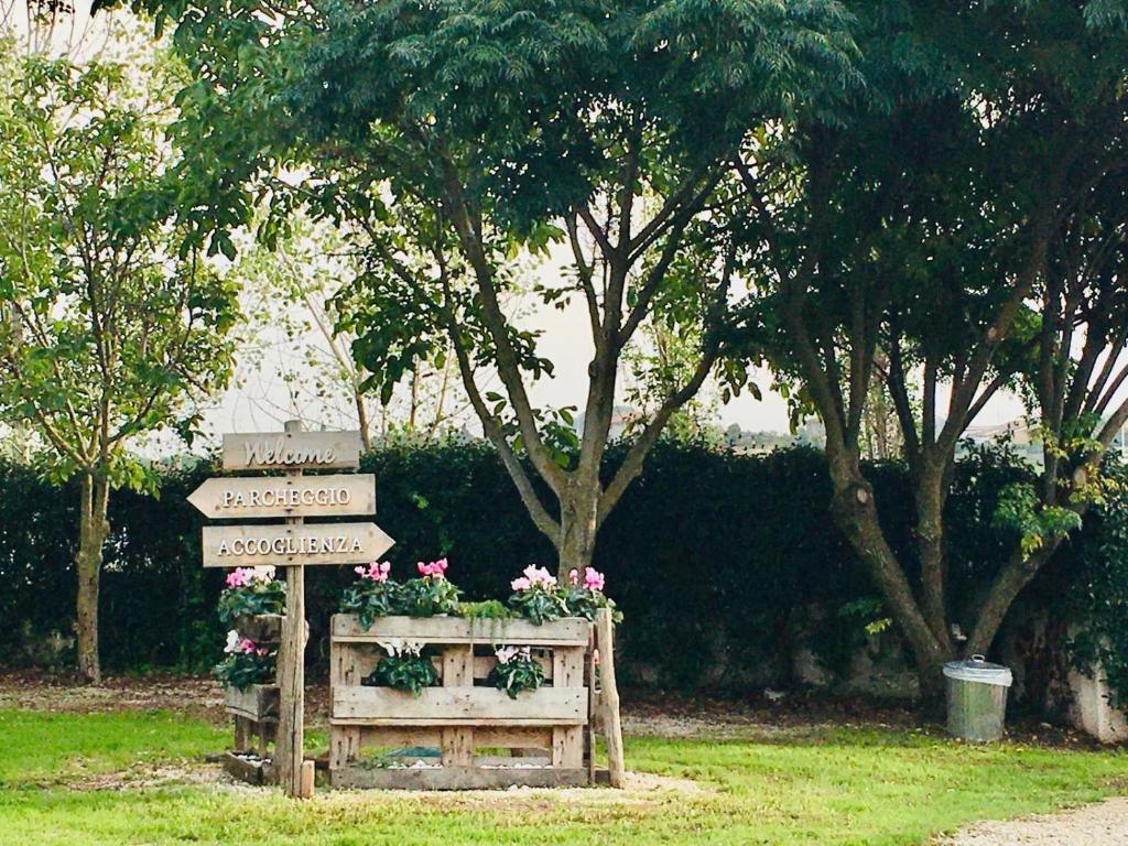 a sign with flowers on it next to a field at country house in Ardea