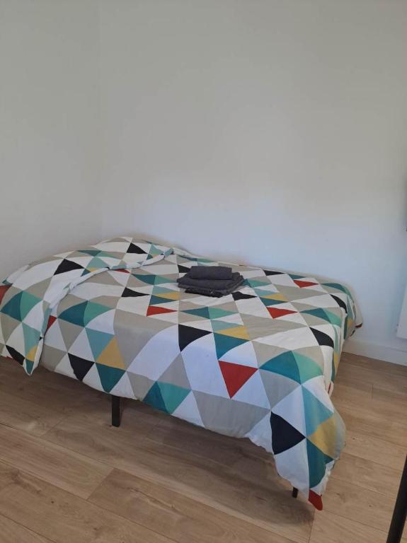 un lit avec une couette colorée dans une chambre dans l'établissement Budgetbnb 195B, studette Porte d 'Italie popular street, à Toulon