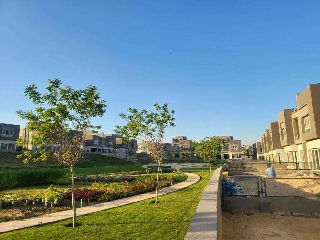 ein Gehweg durch einen Park mit Bäumen und Gebäuden in der Unterkunft luxury apartment in wesal residence compund in Kairo