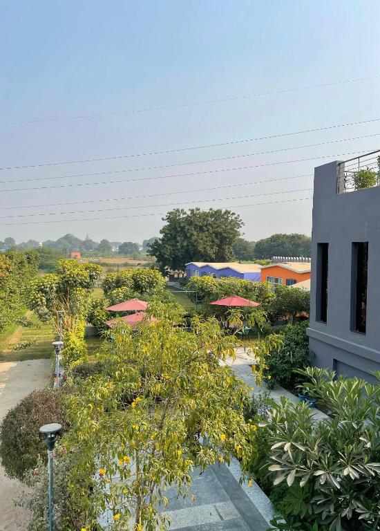 瓦拉纳西The VIA VARANASI Resort的享有带遮阳伞的花园和大楼的景致。