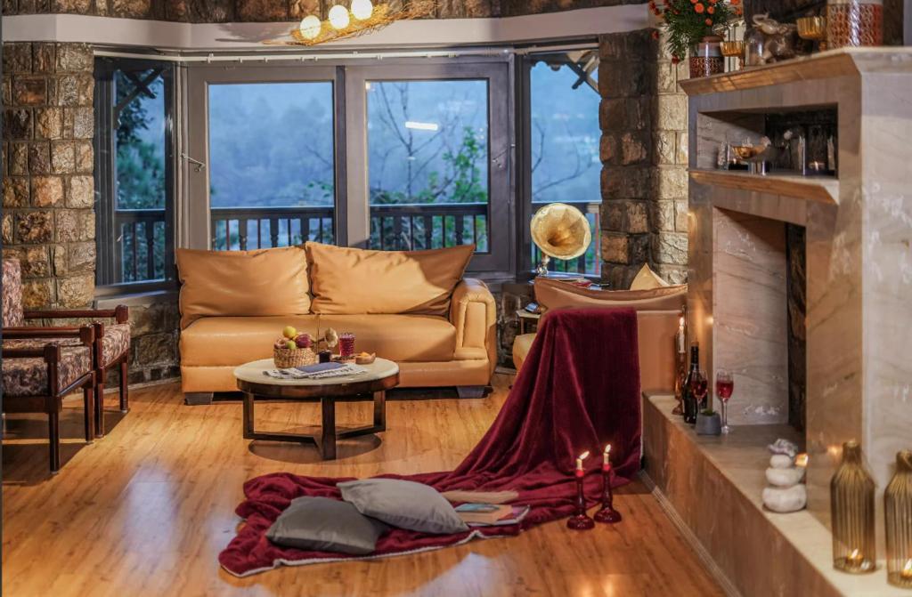 a living room with a couch and a fireplace at The Grey House Exotic Luxury-Villa in Bhīm Tāl