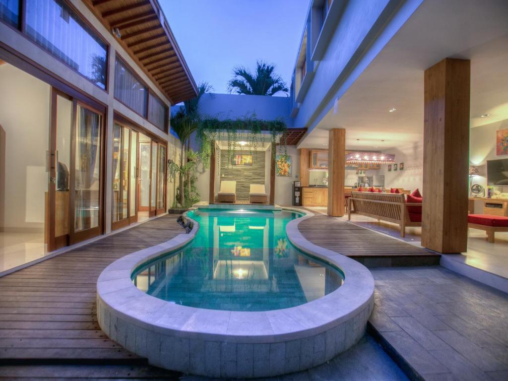 a pool in the middle of a house at Bali Villas Arta in Seminyak