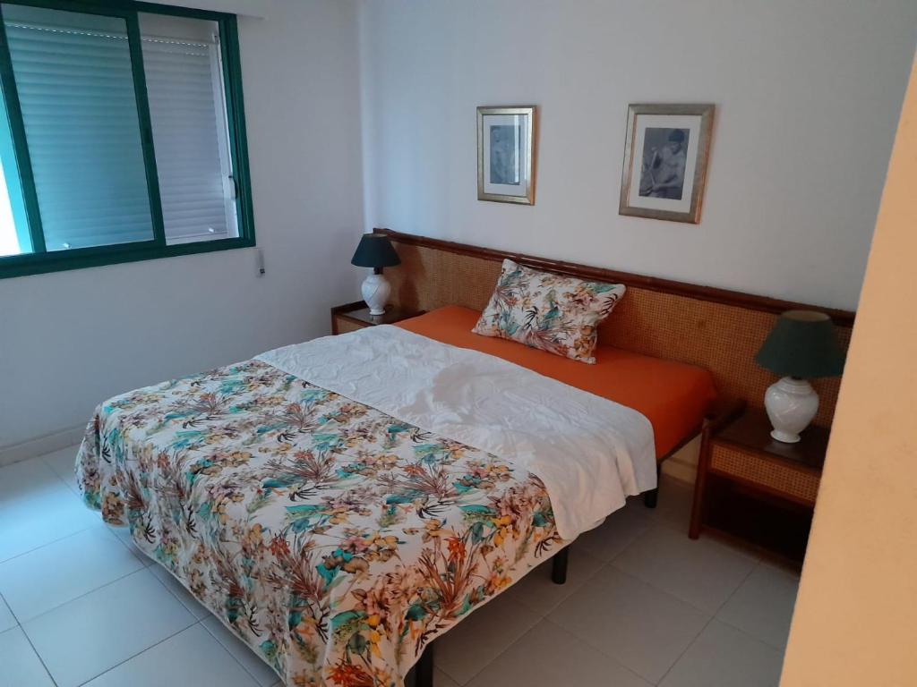 a bedroom with a bed with an orange comforter at Beautiful room with magic ocean view in Arrecife