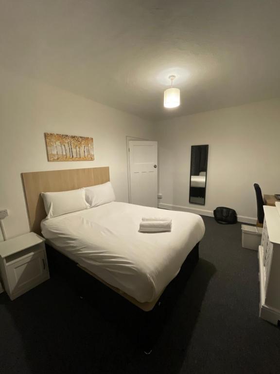 a bedroom with a large bed with white sheets at Sidcup Stay in Sidcup