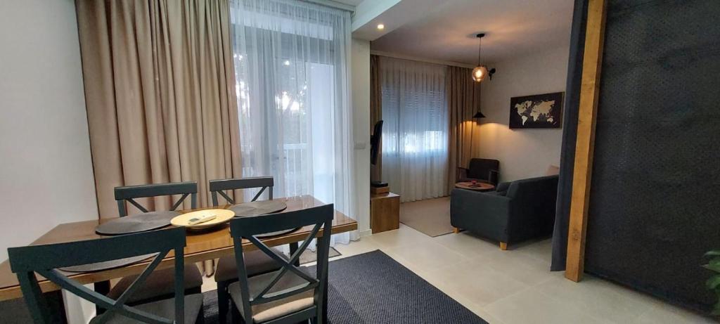 a room with a table and chairs and a living room at Apartman Tivat - Centar 1 in Tivat