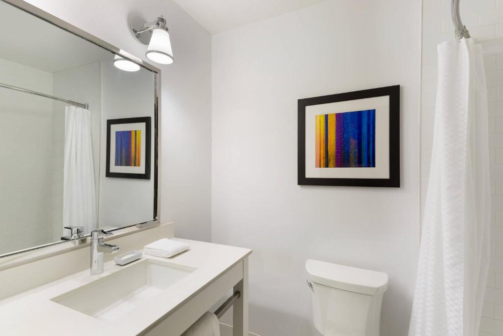 a bathroom with a sink and a toilet and a mirror at Four Points by Sheraton Surrey in Surrey