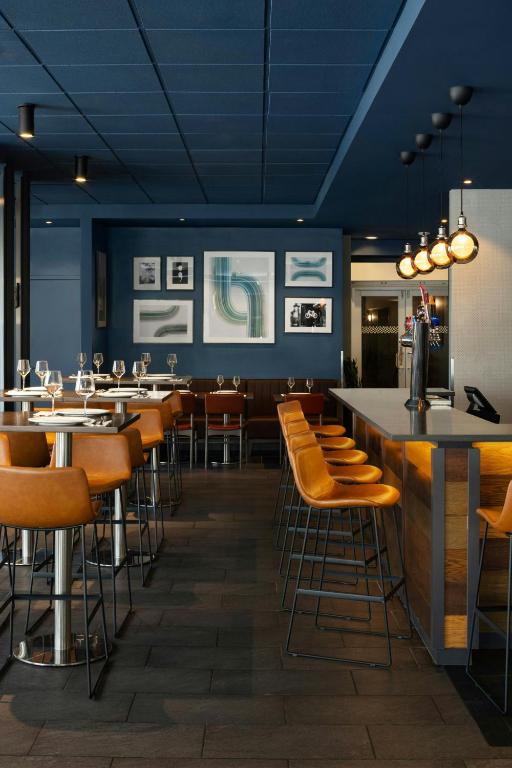 a restaurant with tables and chairs and a bar at Four Points by Sheraton Surrey in Surrey