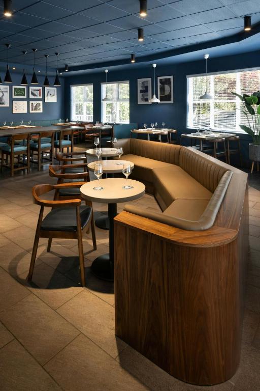 a restaurant with a couch and tables and chairs at Four Points by Sheraton Surrey in Surrey