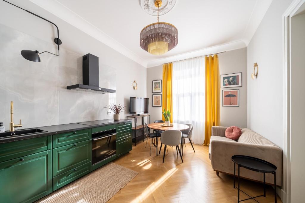 a kitchen with green cabinets and a living room at Luxury Design Apartment Riga in Rīga