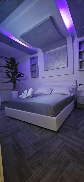 a bedroom with a large bed with a purple lighting at La Suite di FiloGà in Vieste