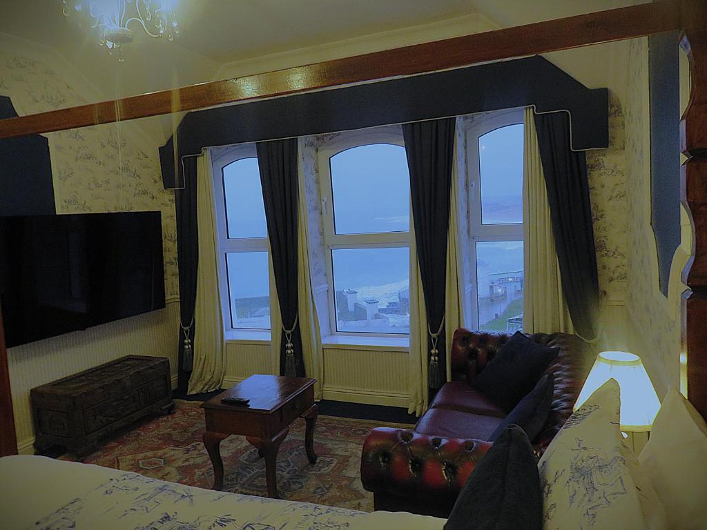 a living room with a couch and two windows at Albany Lodge in Portrush