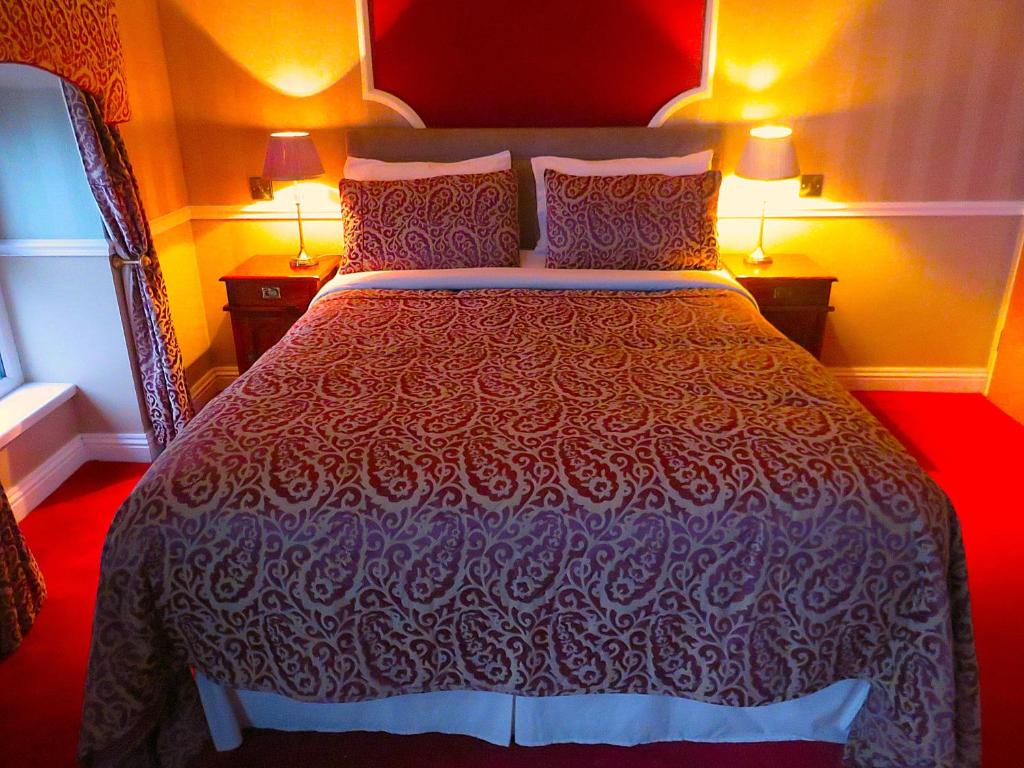 a large bed in a room with two lamps at Albany Lodge in Portrush