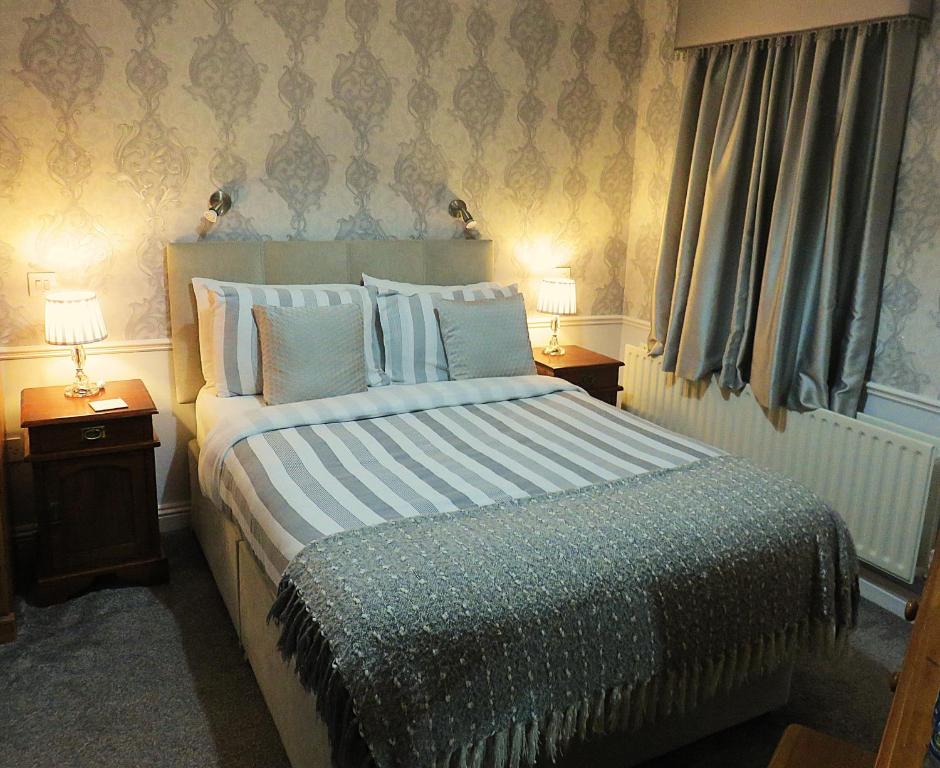 a bedroom with a large bed with two night stands at Albany Lodge in Portrush