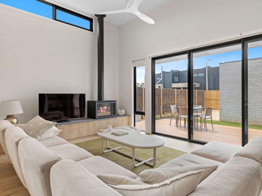 a living room with a white couch and a table at Wirilda Retreat in Inverloch