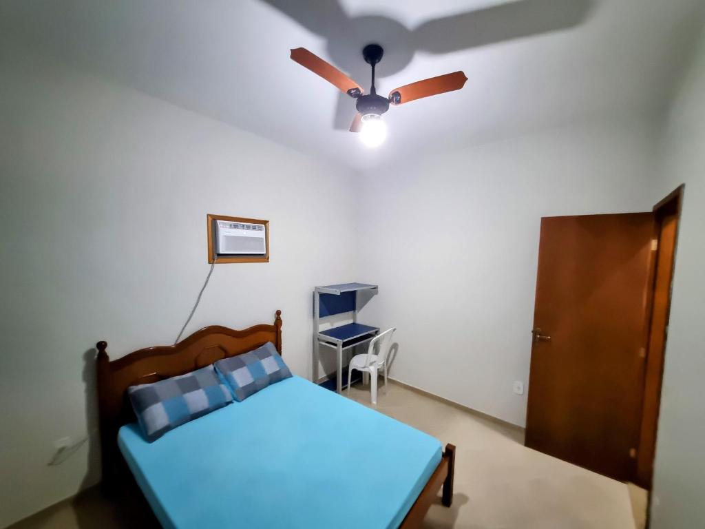 um quarto com uma ventoinha de tecto e uma cama em Apartamento Vip no Frade em Angra dos Reis