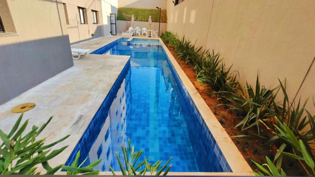 a swimming pool with blue water in a building at 024 - Apto Studio Liberdade Sé 500'Metrô in Sao Paulo