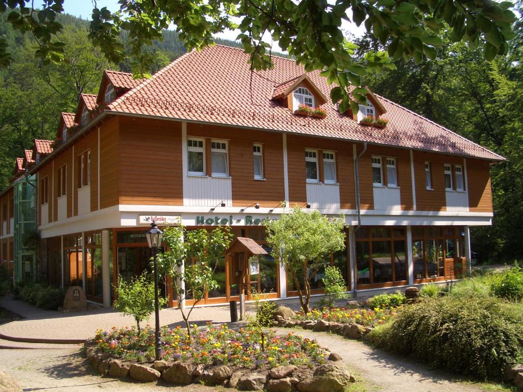 a large wooden building with a garden in front of it at Kurpark Flair Hotel Im Ilsetal in Ilsenburg