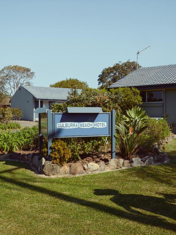 a sign in a yard in front of a house at Culburra Beach Motel in Culburra Beach
