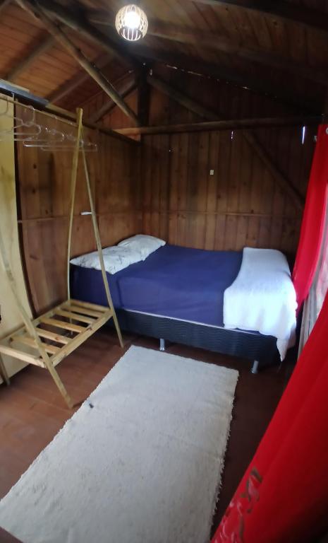 a bedroom with a bunk bed and a ladder in a tent at Cabana 02 superior in Imbituba