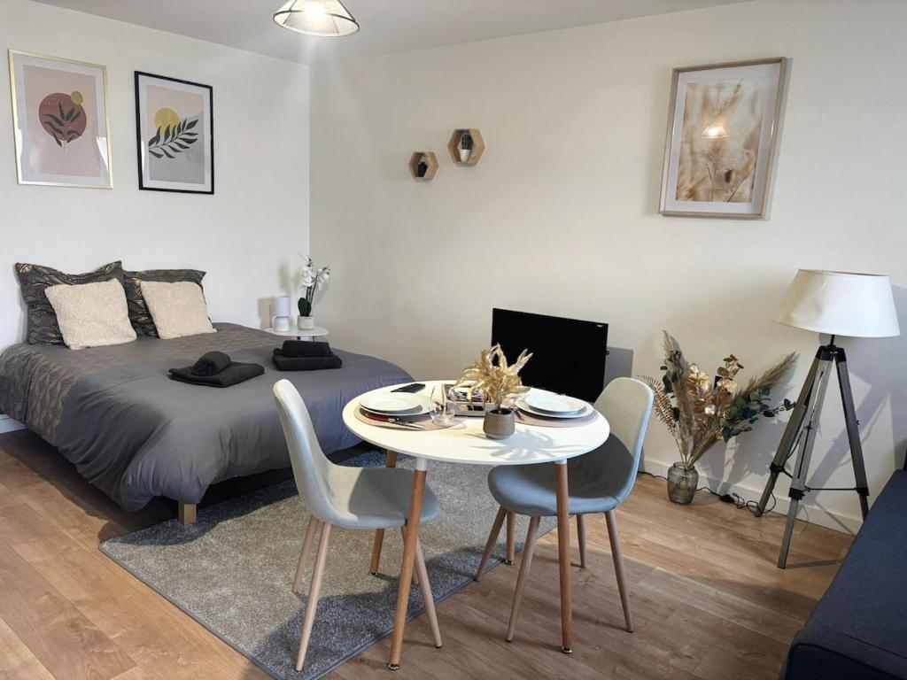 une chambre avec un lit, une table et des chaises dans l'établissement Studio cosy en centre-ville, à Évreux