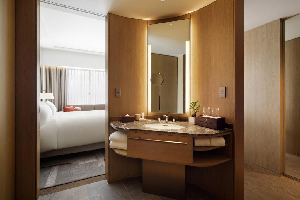 a bathroom with a sink and a bed and a mirror at JW Marriott Hotel Nara in Nara