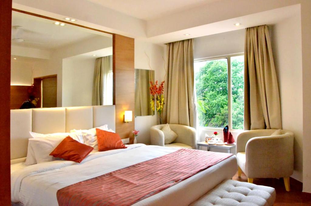 um quarto com uma cama grande e uma janela grande em Hotel Landmark em Gwalior
