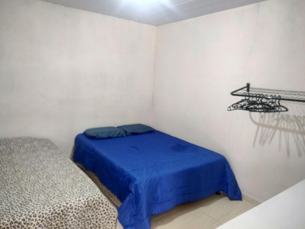 a bedroom with a blue bed in a room at Rancho Vovo Creuza Proximo a diversas cachoeiras in Alfredo Chaves