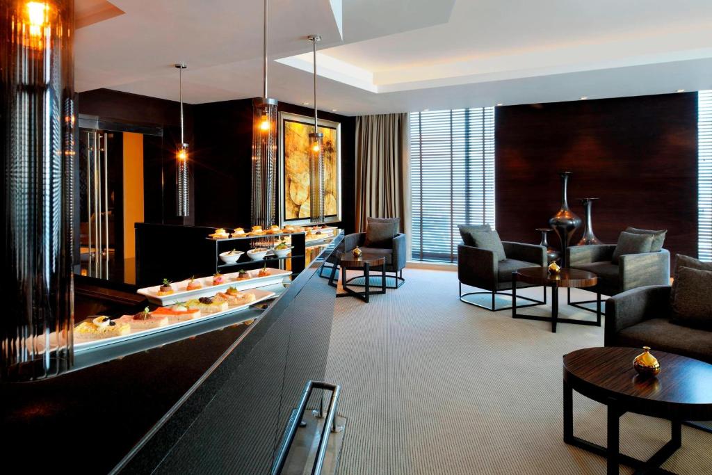 a lobby of a hotel with chairs and a counter at JW Marriott Marquis Hotel Dubai in Dubai